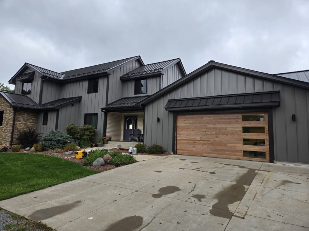 A modern wooden garage door with horizontal panels and windows installed by LabraDoor Overhead Services in Eau Claire, WI.