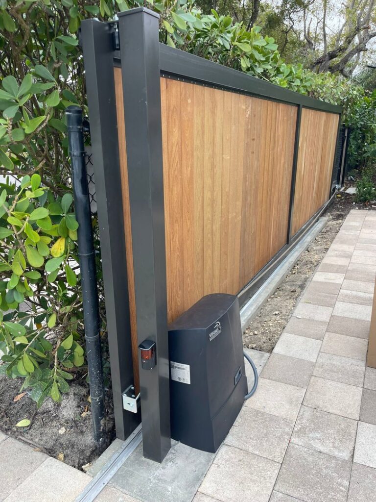 A modern wooden-panel sliding gate with a gate operator motor installed by Motor & Fence Solutions in Miami, FL.
