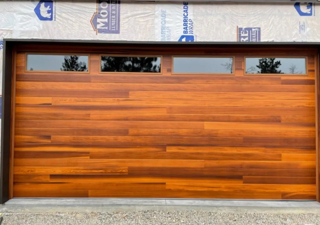 A stylish modern wooden plank garage door with horizontal windows, installed by Your Other Front Door LLC in Lakewood, CO.