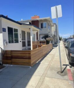 A modern wooden privacy fence or screen installed along a sidewalk by Coastline Gate Repair in Los Angeles, CA.