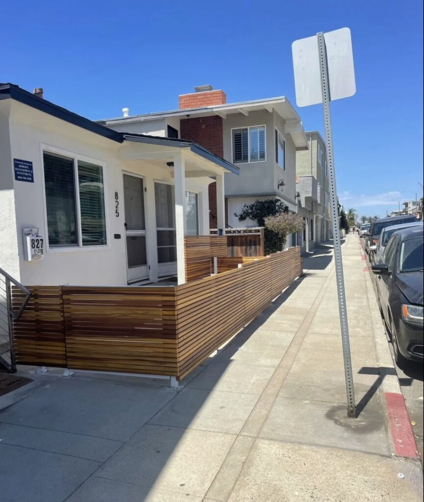 A modern wooden privacy fence or screen installed along a sidewalk by Coastline Gate Repair in Los Angeles, CA.