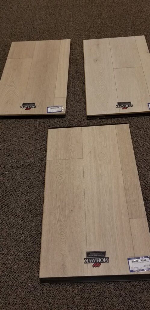 Mohawk laminate flooring samples displayed on a carpeted floor at ProSource Flooring Kitchen & Bath of Naperville, IL.