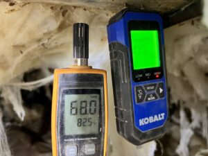 Technician using moisture and humidity meters during a crawl space inspection by Perry Crawl Space & Pest Control Solutions LLC in Chesapeake, VA.