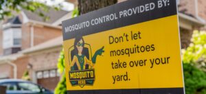 A Mosquito Hero yard sign advertising mosquito control services in front of a residential home in Champaign, IL.