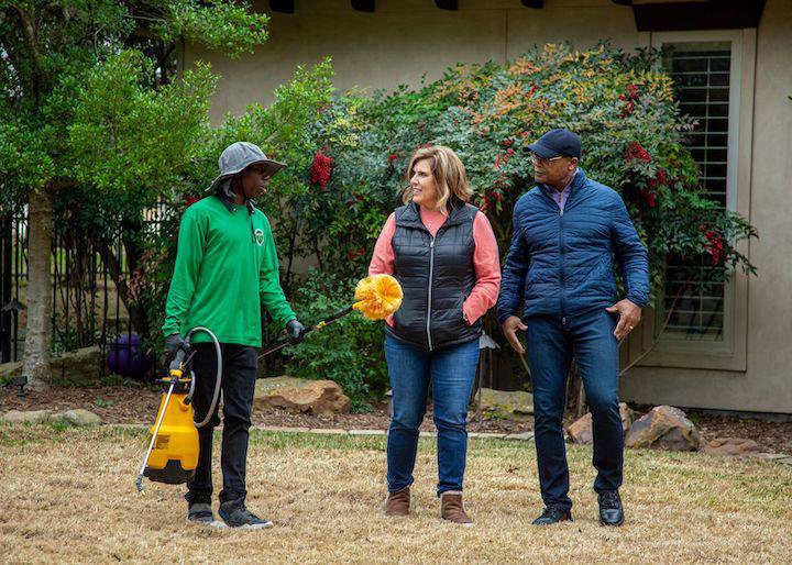 A Mosquito Joe technician explaining pest control service to customers in their yard in Encinitas-Del Mar, San Diego, CA.