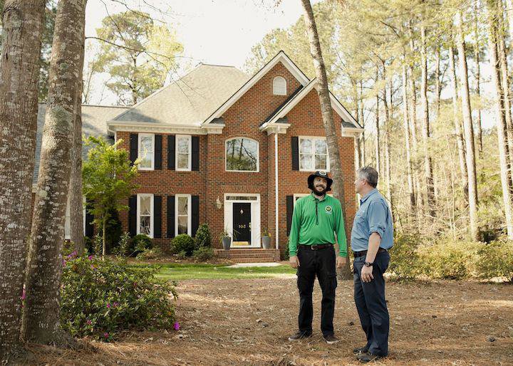 A Mosquito Joe technician consulting with a homeowner in front of their house in Newark, DE.