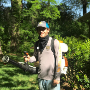 A Mosquito Patrol technician applying pest control treatment with a backpack sprayer in Burlington, NC.