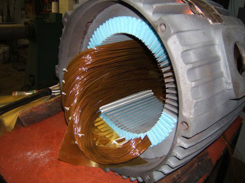 Copper coils being wound into an electric motor stator during a rewinding service by Alexco Max Electricals And Construction in Madina, GH.