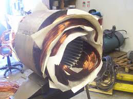 An electric motor stator with copper windings and insulating paper, part of the rewinding process by Alexco Max Electricals And Construction in Madina, GH.