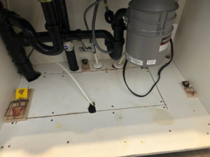 Mouse traps placed under a kitchen sink for rodent control by Thrive Pest Management in Sandy, UT