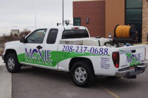 A Moxie Pest Control service truck with tanks and hose reel for pest treatment in Chubbuck, ID.