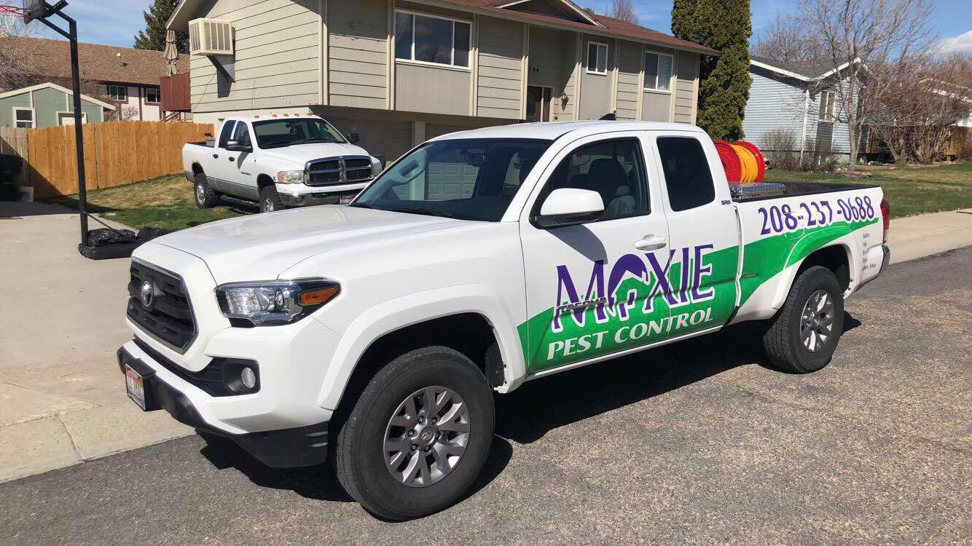 A Moxie Pest Control truck with equipment parked at a residential property for a pest control job in Chubbuck, ID.