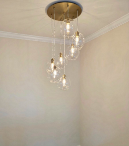 A beautiful multi-bulb modern chandelier with clear glass globes installed by Anchor Electric LLC in Wilmington, NC