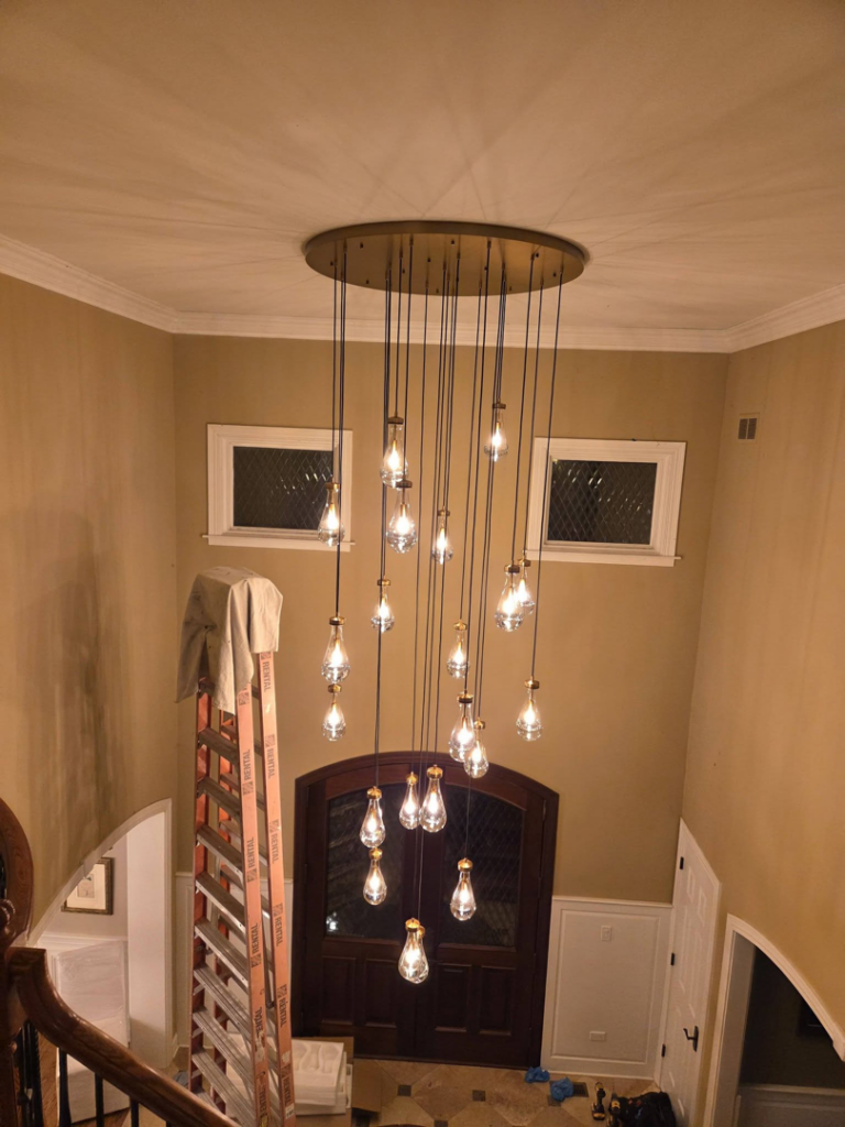 A multi-bulb chandelier installed in a grand entryway by Ed's Electrical & Mounting services in Chicago, IL.