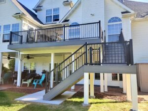 A newly constructed multi-level deck with black railings and stairs, built by Chesley Fence & Deck in Fairview Heights, IL.