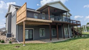 A multi-level deck with black metal railings and a wooden privacy screen installed by Babb Custom Fence in Sioux Falls, SD.