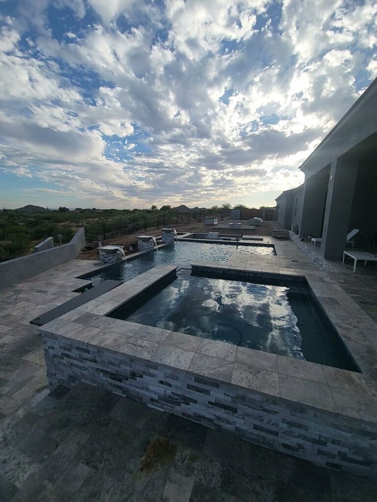 A stunning multi-level pool and spa with elegant stone cladding, completed by EZ POOL Solutions in Tucson, AZ
