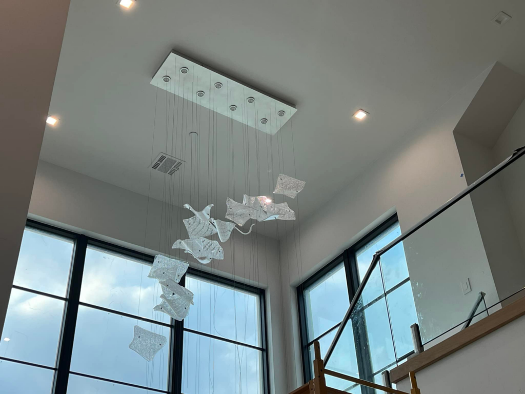 A multi-pendant chandelier with unique glass elements installed by Focal Electric Company in Dallas, TX.
