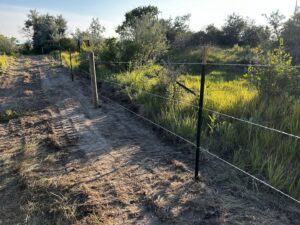 Multi-strand wire fence with T-posts and wooden corner post by Cowboy State Fencing LLC in Riverton, WY.
