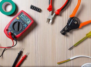 A multimeter and various electrician tools like wire strippers, pliers, and screwdrivers, used by Jett Electric in Chicago, IL