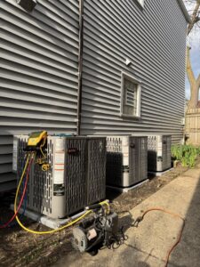 Multiple outdoor air conditioning units undergoing service or installation by Hvac Buddies in Chicago, IL