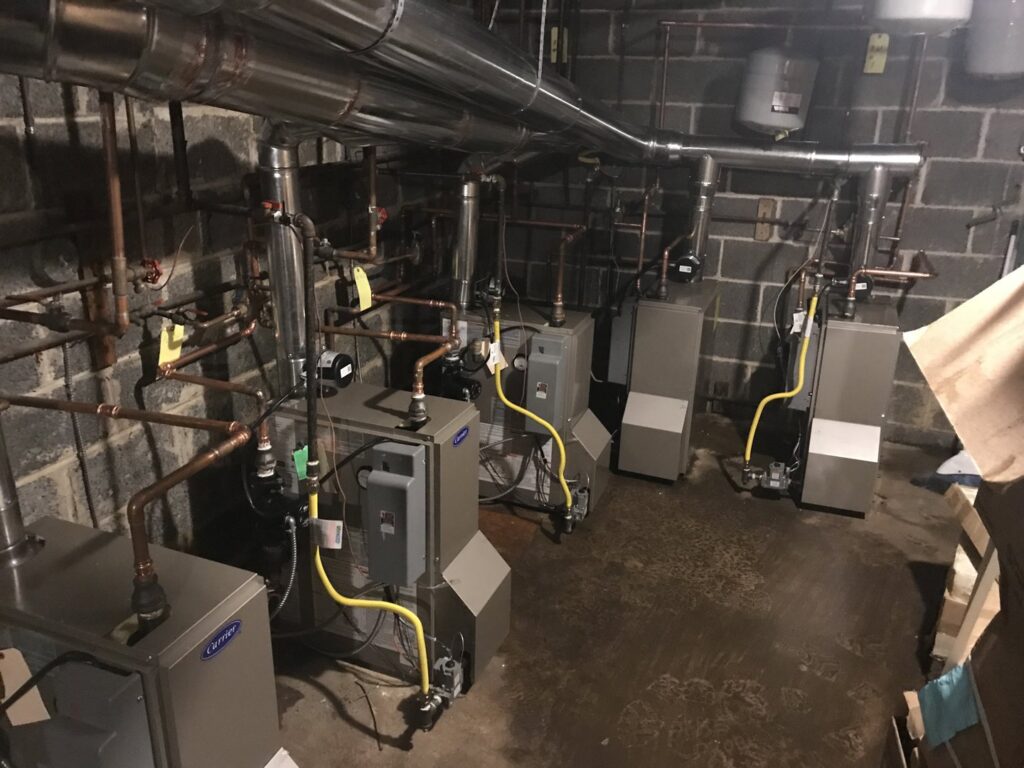 Multiple Carrier brand boilers and associated piping installed in a utility room by Air Done Right in Philadelphia, PA.