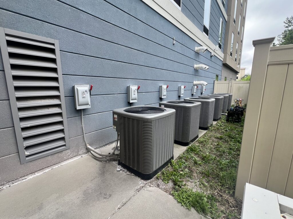Multiple outdoor commercial air conditioning units installed along a building by Reliable Heating and Air LLC in Summerville, SC.