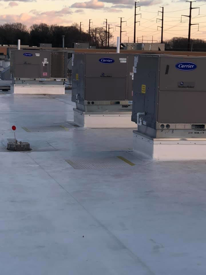 Multiple Carrier WeatherMaker commercial HVAC units installed on a large rooftop by Air Quality, LLC in Cranston, RI