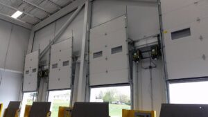 Interior view of a commercial building with multiple overhead doors and openers, installed by Tri County Overhead Door Service Inc in New London, WI.