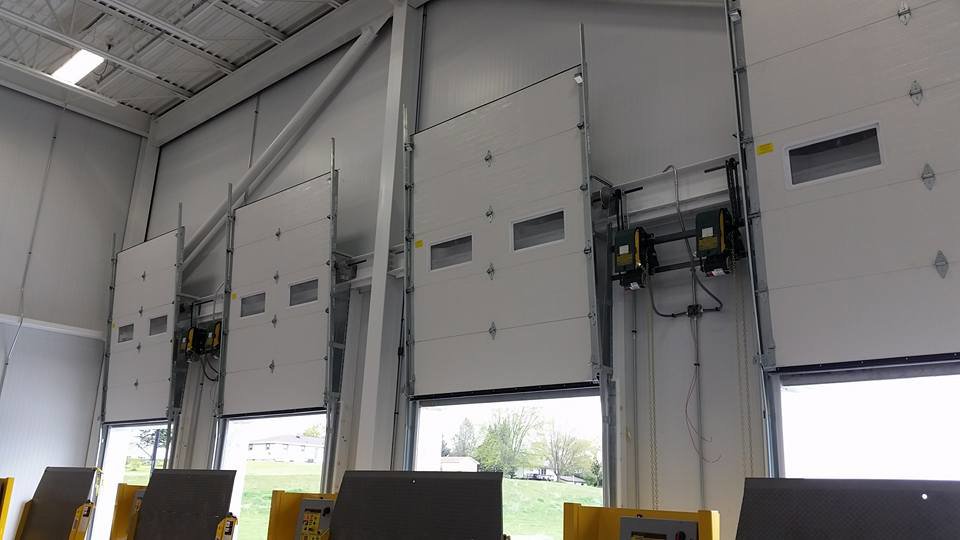 Interior view of a commercial building with multiple overhead doors and openers, installed by Tri County Overhead Door Service Inc in New London, WI.