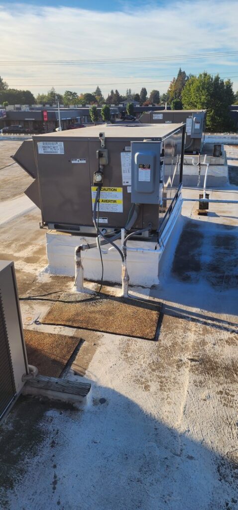 Multiple commercial rooftop HVAC units on a building, serviced by Nelke Mechanical in Keizer, OR.