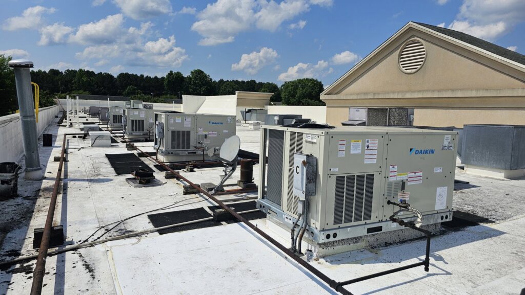 Several commercial rooftop HVAC units installed on a building by Peak Seasons HVAC in Raleigh, NC.