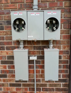 Multiple electrical meter bases and conduit installed on a brick wall by Raschke & Sons Electric in Chattanooga, TN