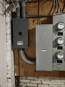 Multiple electrical meters and a main disconnect box with a high voltage warning, installed by Mayflower Electric LLC in Knoxville, TN