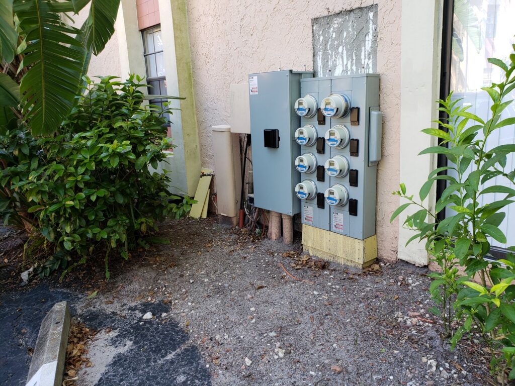 Multiple electrical meters and panels on the exterior of a building, serviced by Electricians On Call in Fort Lauderdale, FL.