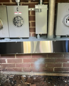 Multiple electrical meters and service panels installed on a brick wall by Sapphire Electric LLC in Jonesboro, GA.