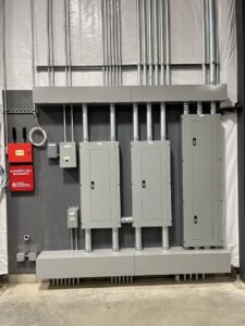 Multiple electrical panels and conduit runs installed on a wall by Patriot Electric L.L.C in Phoenix, AZ