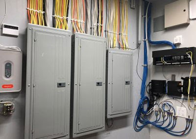 Multiple electrical panels and organized wiring installed in a utility room by T & M Electric Inc in Bismarck, ND