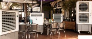 Multiple evaporative coolers providing cooling for an outdoor cafe seating area by Cajun Kooling in Broussard, LA