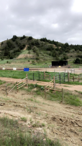 Various types of fences and gates, including wood and metal, in a rural landscape by Bighorn Fencing in Williston, ND.