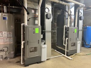 Two furnace systems and a water heater installed in a utility room by Adam's HVAC in Naperville, IL.