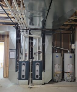 A complex HVAC installation with multiple furnaces, water heaters, and ductwork by Friess Heating & Air Conditioning in Topeka, KS