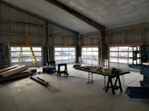 Interior view of a commercial space with multiple glass panel garage doors installed by Colorado Garage Door Pro's in Denver, CO