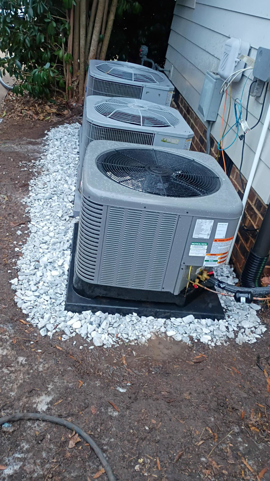 Multiple outdoor HVAC condenser units installed with new gravel at a property by Alianza Mecanica HVAC in Charlotte, NC.