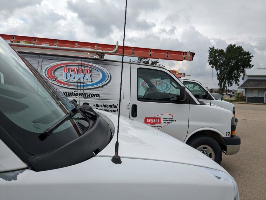 Multiple branded HVAC service vans parked for Marie Keding Bryant Iowa Heating and Cooling in Ankeny, IA.