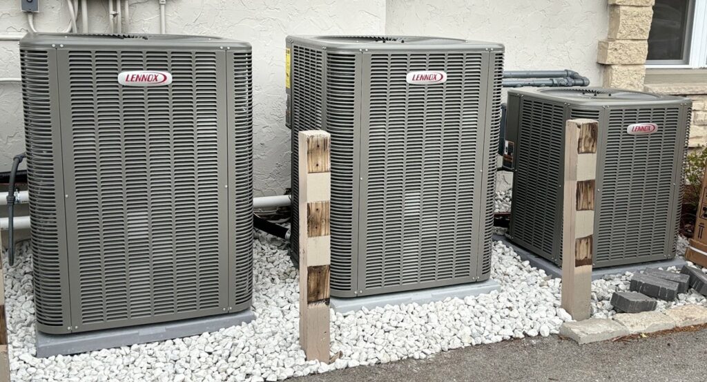 Three Lennox outdoor air conditioning units installed on white gravel by Done Right Air in West Allis, WI