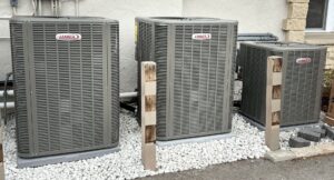 Three Lennox outdoor air conditioning units installed on white gravel by Done Right Air in West Allis, WI