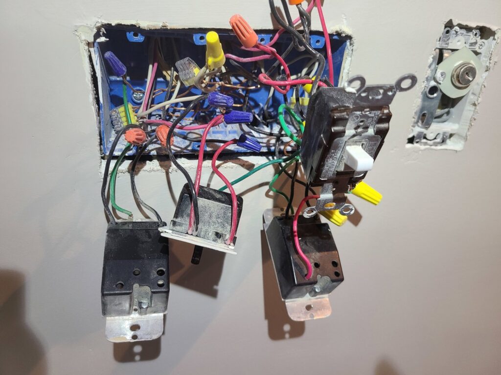 An open electrical box revealing multiple light switches and complex wiring, showcasing an electrician's expertise from 8Thirty Electric, Inc. in Johns Creek, GA.