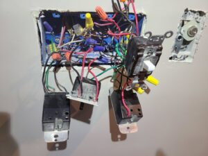 An open electrical box revealing multiple light switches and complex wiring, showcasing an electrician's expertise from 8Thirty Electric, Inc. in Johns Creek, GA.