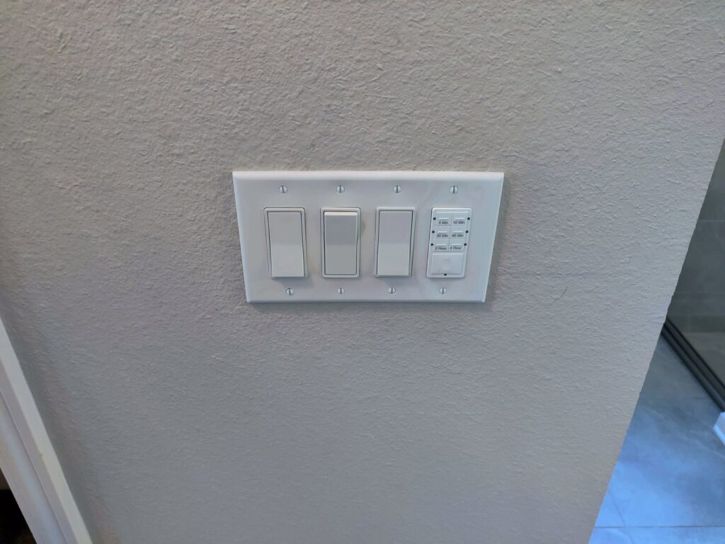 Wall with multiple light switches and a smart timer switch installed by Heck Electric, LLC in Everett, WA